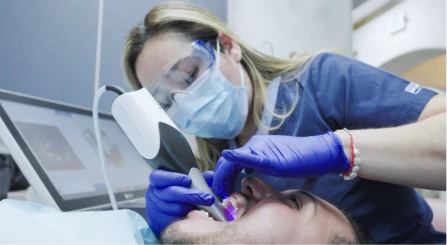 Dentist performing a clinical dental procedure with the assistance of a hygienist.