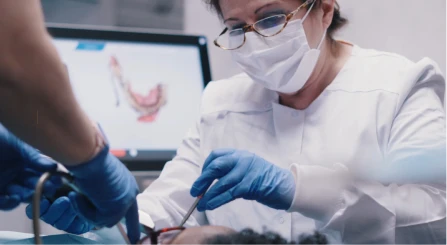 Dentist using a digital intraoral scanner to capture precise tooth images for restorations.