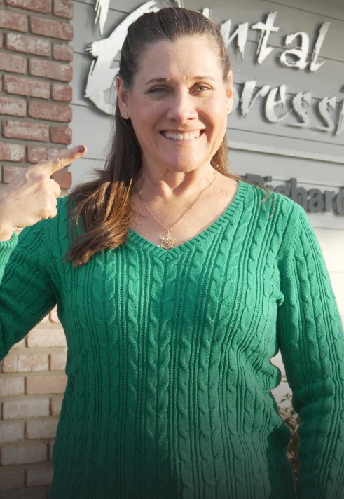 Happy dental patient smiling outside the clinic after cosmetic treatment.