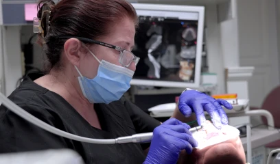 Dentist performing oral examination; advanced dental care technology available in San Diego for Inlays and Onlays.