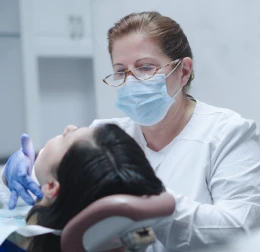 Dentist examining a patient’s teeth during a routine dental appointment.