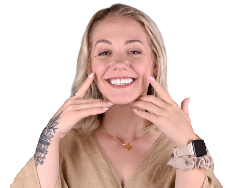 Smiling young woman pointing at her teeth after receiving cosmetic dental treatment.